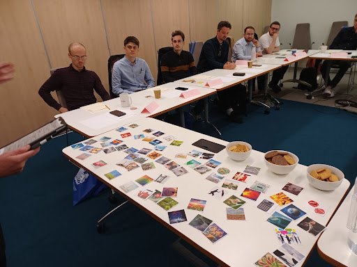 those on the Software Development Programme are pictured in a workshop. They are seen sitting listening to a standing speaker, with a range of pictures to prompt thinking shown 