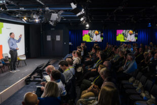 photo taken from Government Digital and Data event, presenter on stage with audience