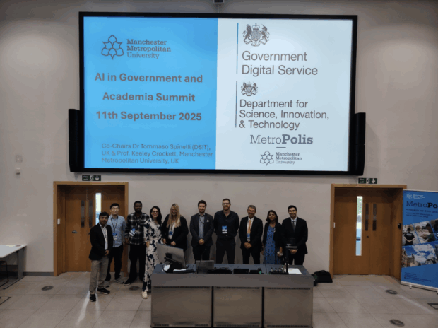 A group of individuals and speakers from the AI Summit stood at the front of the event smiling.